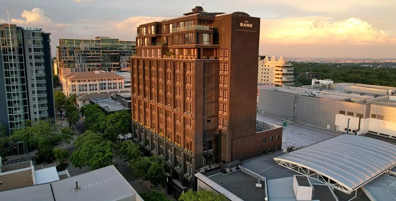 Hyde Johannesburg marks a major milestone for Ennismore as the brand’s first hotel in Africa. (Image source: Ennismore) A wide shot of the Hyde Johannesburg hotel in South Africa against a sunset.