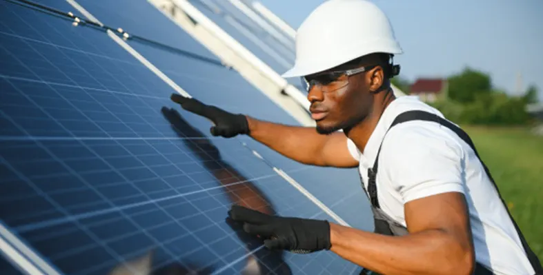 Eskom introduces its first Renewable Energy Offtake Programme, enabling businesses to secure clean power through long-term PPAs. (Image source: Eskom) Man_trying_to_fix_the_solar_panel